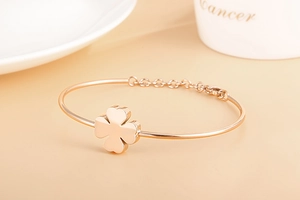 Detail view of a rose gold clover bracelet with an adjustable extension chain and clasp