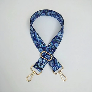 Detail view of ethnic blue paisley wide strap with gold metal lobster clasps