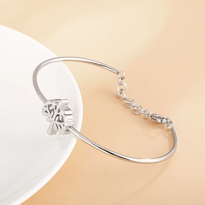 Bracelet arbre de vie en argent poli avec chaîne réglable sur une assiette en céramique blanche
