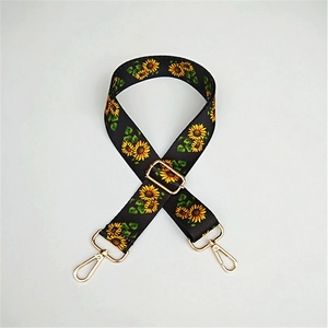 Detail of adjustable black strap with sunflower patterns and gold metal swivel hooks