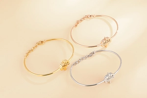 Détail de trois bracelets arbre de vie en finitions or, or rose et argent poli