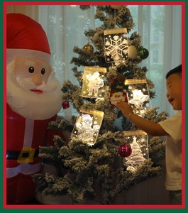 Close-up of 3D warm white LED acrylic snowflake and snowman hanging lights on Christmas tree