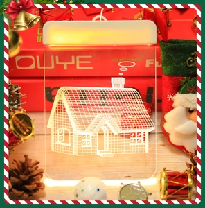 3D acrylic Christmas night light featuring a festive house design on a wooden surface
