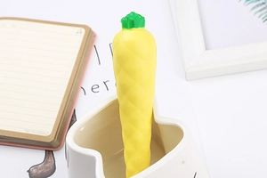 Close-up of cute carrot-shaped stress relief pen inside a white ceramic bowl on a desk