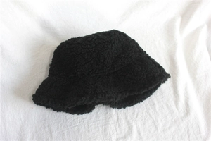 Detail of black teddy plush bucket hat showing thick warm faux shearling texture