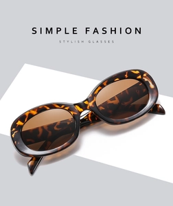 Close-up of retro oval sunglasses featuring tortoise shell frames and brown tinted lenses