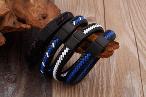 Détail de bracelets en cuir tressé avec fermoirs magnétiques sur fond de bois rustique