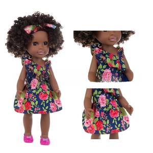 Close-up of 14-inch African girl doll with brown afro hair and blue floral dress