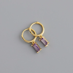 Détail de boucles d'oreilles créoles dorées avec pendentifs rectangulaires violets