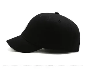 Close-up of a black short brim baseball cap with a white square logo on the side profile
