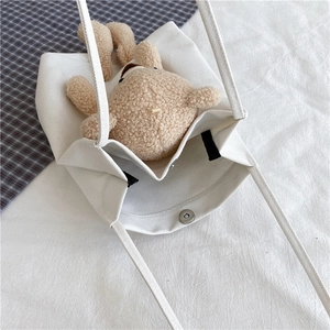 Détail de l'intérieur du sac en toile blanche avec boucle magnétique et ours en peluche