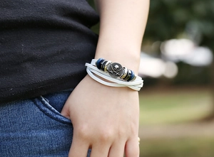 Close-up of woven leather multi-layer bracelet with skull charm and tiger eye beads