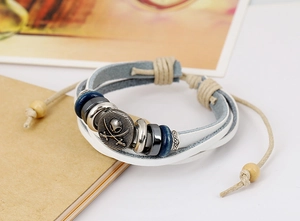 Close-up of multilayer leather bracelet featuring pirate skull charm and wood beads
