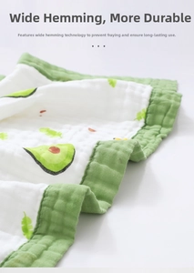 Close-up of baby gauze blanket showing durable green wide-edge binding and avocado print