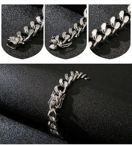 Macro detail of silver stainless steel Cuban chain bracelet with secure mechanical clasp