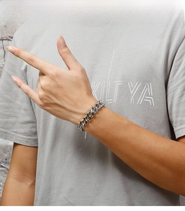 Close-up of polished stainless steel cuban link bracelet on male model wrist
