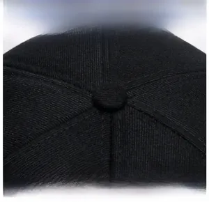 Detailed macro view of the stitched crown and top button on a black winter baseball cap