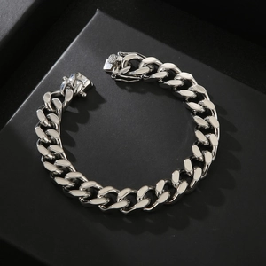 Mens minimalist silver stainless steel curb chain bracelet on a black textured background
