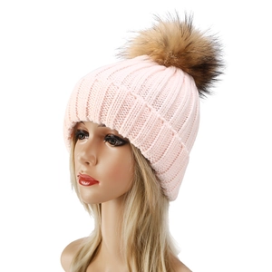 Nahaufnahme der rosa Strickmütze mit flauschigem braunem Pelzbommel auf einem Display