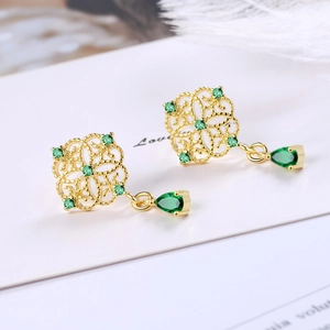 Vintage gold hollow flower earrings with emerald green teardrop pendants and white feathers