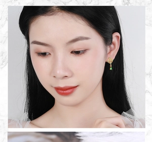 Detail of Chinese style emerald green teardrop earring with golden vintage hollowed pattern
