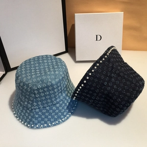 Detail of denim bucket hats with floral jacquard patterns and elegant pearl trim decoration