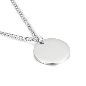 Collana minimalista con ciondolo rotondo argento e catena cubana su sfondo bianco