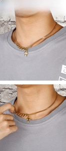 Detail of gold mixed Cuban and curb chain necklace featuring a vintage engraved cross pendant