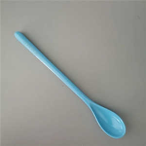Detailed close-up of light blue long-handled plastic dessert spoon on gray background