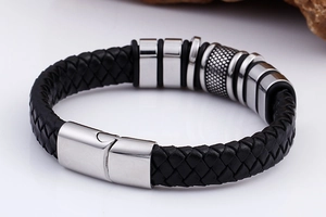 Detail of black braided leather men's bracelet with silver steel rings and magnetic clasp