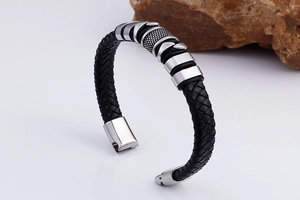 Close-up of black braided leather men's bracelet with polished stainless steel clasp
