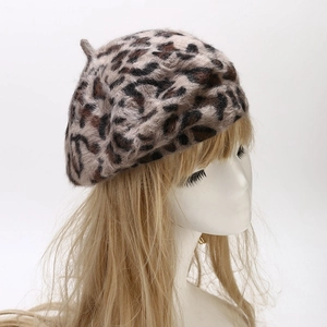 Close-up of soft plush leopard print beret hat showing fuzzy texture and animal pattern