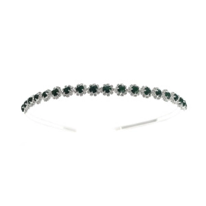 Detailed view of silver bridal tiara with emerald green stones and white rhinestones