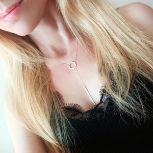 Silver Y-shape geometric necklace with circle and bar pendant worn by a model