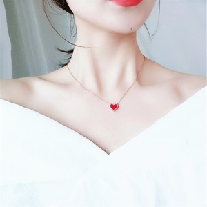 Double-sided red heart pendant necklace in rose gold finish on a female model