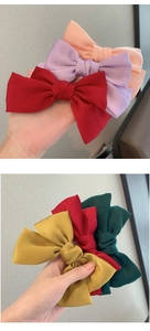 Dettaglio di grandi fiocchi per capelli in raso colorato in varie tonalità eleganti