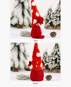 Side and back view of a red Christmas plush gnome with dots and white beard in winter setting