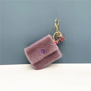 Detail of purple faux fur mini coin purse featuring gold clasp and red leather tassel