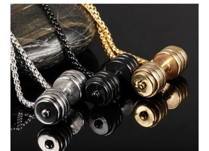 Three dumbbell pendants in silver, black, and gold colors on reflective black surface