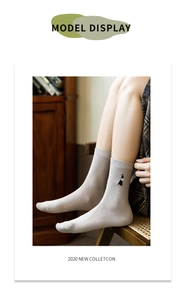 Detailansicht grauer Baumwollsocken mit Cartoon-Stickerei in gemütlicher Retro-Umgebung