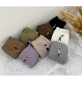 Detail von bunten Baumwollsocken mit Mini-Charakter-Stickerei und feiner Strickstruktur