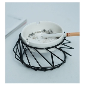 Top view of creative geometric ashtray with white ceramic bowl and black metal frame