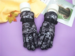 Detail of kids winter camouflage ski gloves featuring adjustable wrist straps and padding
