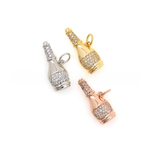 Detailed macro of 18k gold plated champagne bottle charms with micro-pave zircons