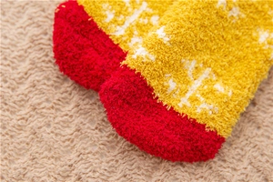Detailed close-up of warm coral fleece winter socks with red and yellow contrast texture