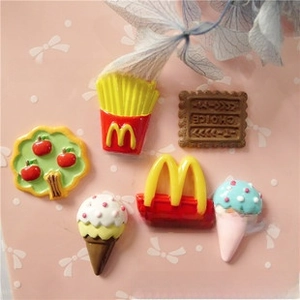 Detailed view of DIY resin food charms including chocolate sticks and French fries icons