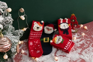 Close-up of festive Christmas socks featuring 3D cartoon Santa and bear embroidery details