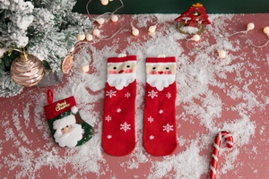 Detailed close-up of red Christmas socks with Santa Claus embroidery and knit texture