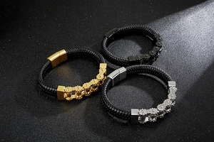 Close-up of woven leather bracelets with steel gear accents in gold, silver, and black