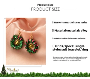 Close-up of alloy Christmas wreath earrings with gold bells on pink silk background